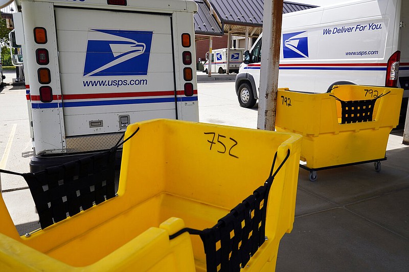 Mail delivery vehicles are parked outside a post office in Boys Town, Neb., Tuesday, Aug. 18, 2020. The Postmaster general announced Tuesday he is halting some operational changes to mail delivery that critics warned were causing widespread delays and could disrupt voting in the November election. Postmaster General Louis DeJoy said he would "suspend" his initiatives until after the election "to avoid even the appearance of impact on election mail." (AP Photo/Nati Harnik)