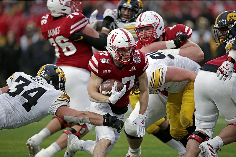 AP photo by Nati Harink / Nebraska running back Wyatt Mazour, center, runs for a touchdown past Iowa linebacker Kristian Welch on Nov. 29, 2019, in Lincoln, Neb.