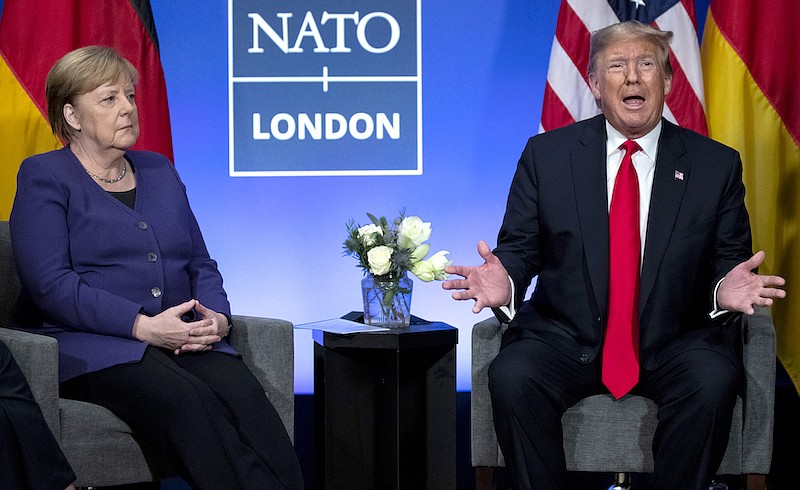 In this Wednesday, Dec. 4, 2019 file photo President Donald Trump meets with German Chancellor Angela Merkel during the NATO summit at The Grove in Watford, England. After more than a year of thinly veiled threats that the United States could start pulling troops out of Germany unless the country increases its defense spending to NATO standards, President Donald Trump appears to be going ahead with the hardball approach with a plan to reduce the American military presence in the country by more than 25 percent. (AP Photo/ Evan Vucci, file)