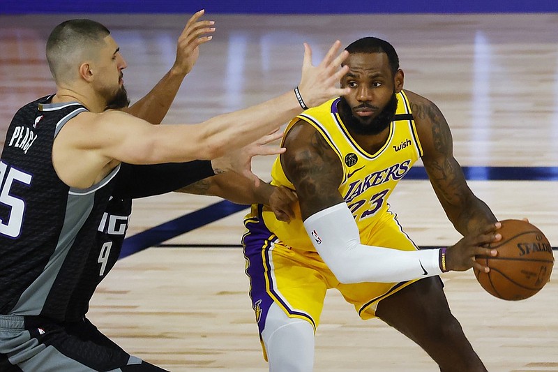 Los Angeles Lakers' LeBron James (23) is pressured by Sacramento Kings' Alex Len (25) during the first half of an NBA basketball game Thursday, Aug. 13, 2020, in Lake Buena Vista, Fla. (Kevin C. Cox/Pool Photo via AP)

