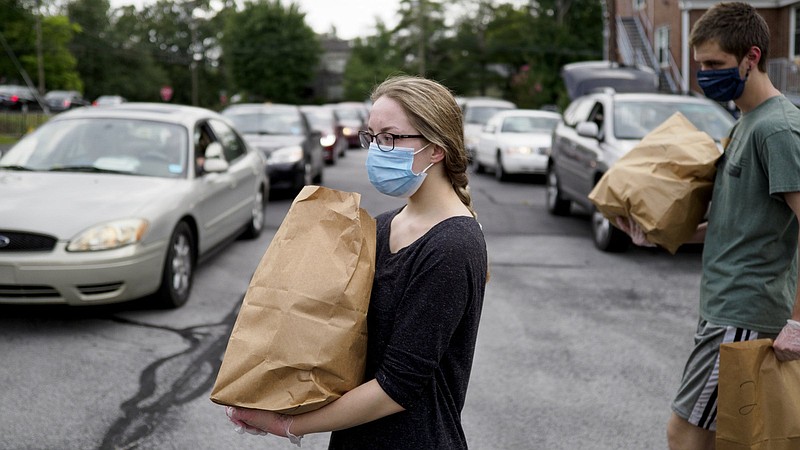 Staff photo by C.B. Schmelter / Sonya Murphy, left, and Deacon Murphy help distribute bags of food from the Red Bank Community Food Pantry at Red Bank United Methodist Church on Thursday, Aug. 20, 2020 in Chattanooga, Tenn.