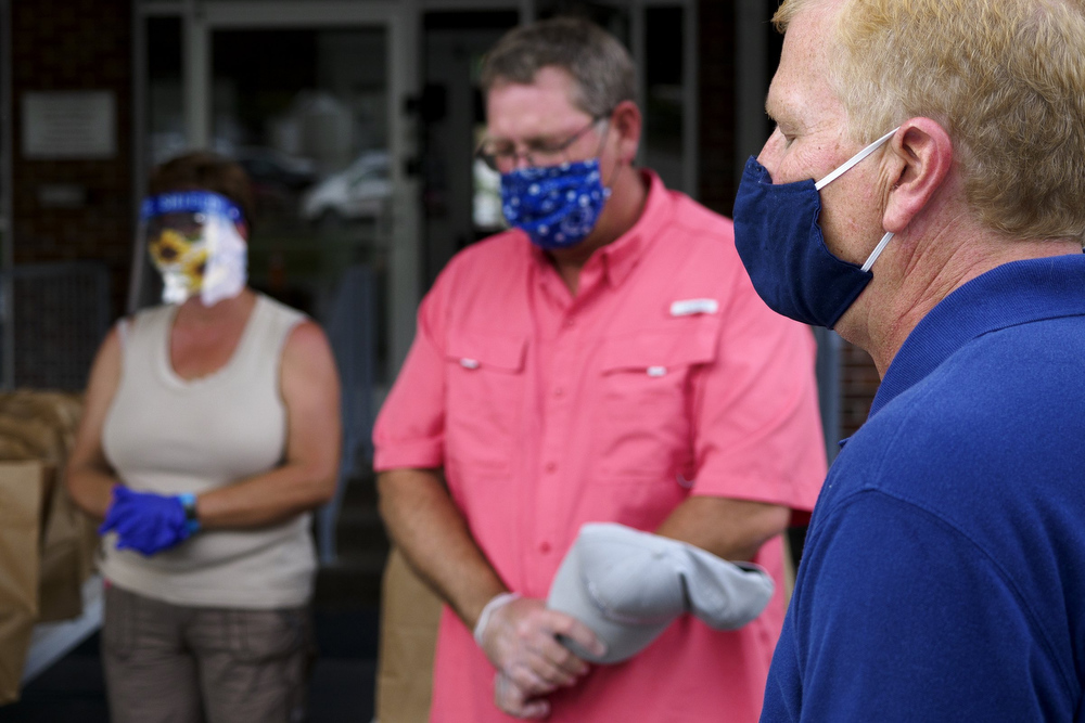 Staff photo by C.B. Schmelter / Pastor Ken Sauer leads a prayer before food is distributed by the Red Bank Community Food Pantry at Red Bank United Methodist Church on Thursday, Aug. 20, 2020 in Chattanooga, Tenn.