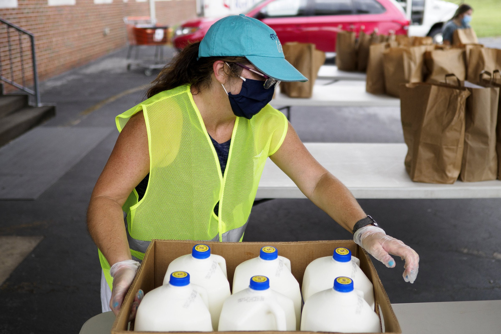 Staff photo by C.B. Schmelter / Sonya Keller brings out more milk to be distributed at Red Bank United Methodist Church on Thursday, Aug. 20, 2020 in Chattanooga, Tenn.