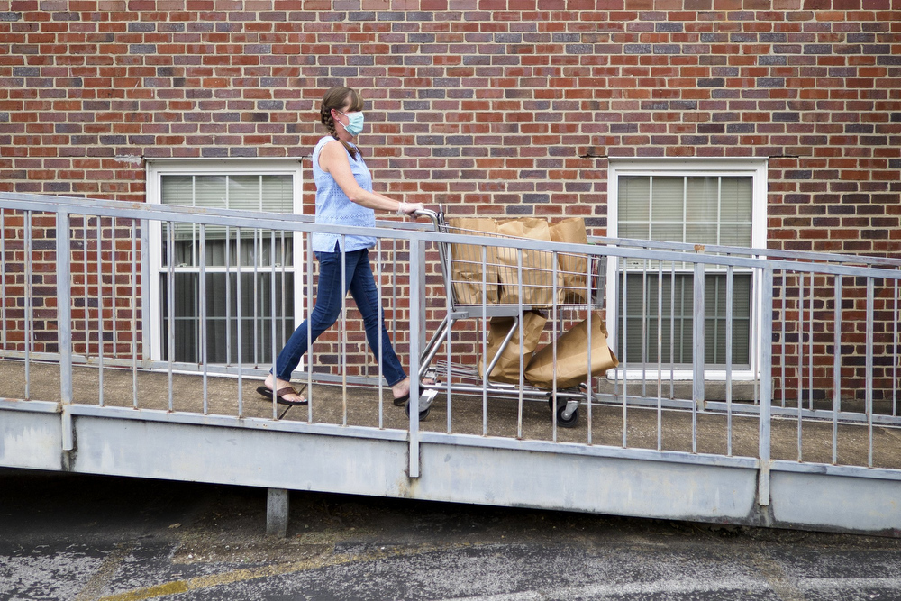 Staff photo by C.B. Schmelter / Paige Bohne brings out more food to be distributed at Red Bank United Methodist Church on Thursday, Aug. 20, 2020 in Chattanooga, Tenn.