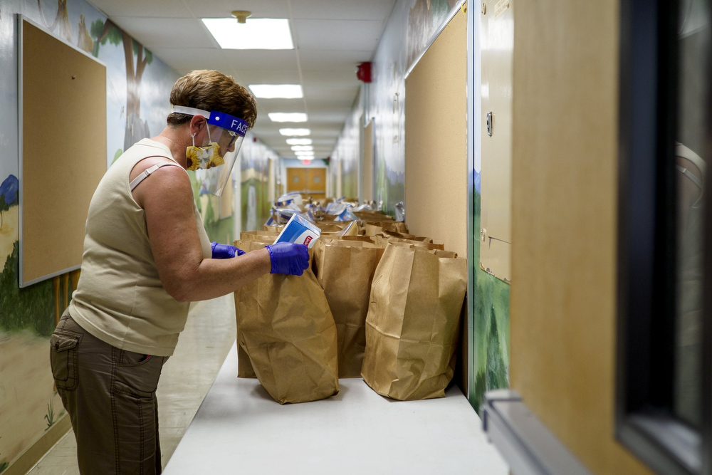 Staff photo by C.B. Schmelter / Mary Vickery brings out more bags of food to be distributed at Red Bank United Methodist Church on Thursday, Aug. 20, 2020 in Chattanooga, Tenn.