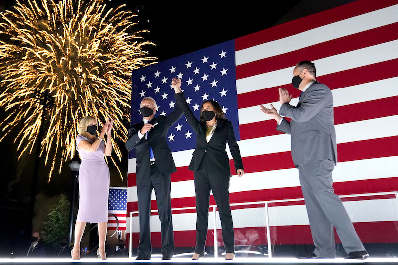 Democratic presidential candidate former Vice President Joe Biden, with Democratic vice presidential candidate Sen. Kamala Harris, D-Calif., raise their arms up as fireworks go off in the background during the fourth day of the Democratic National Convention, Thursday, Aug. 20, 2020, at the Chase Center in Wilmington, Del. Looking on are Jill Biden, far left, and Harris' husband Doug Emhoff, far right. (AP Photo/Andrew Harnik)