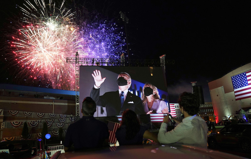 Democratic presidential candidate former Vice President Joe Biden, and his wife Jill Biden, are shown on large screens outside the venue where Biden spoke at the conclusion of the final day of the Democratic National Convention, Thursday, Aug. 20, 2020, at the Chase Center in Wilmington, Del. (AP Photo/Carolyn Kaster)