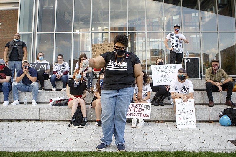 Staff photo by C.B. Schmelter / Marie Mott, a local activist and candidate for Chattanooga City Council, performs a libation during a protest against the killing of George Floyd at Miller Park on Monday, June 1, 2020 in Chattanooga, Tenn. Floyd, 46, died after being handcuffed and pinned for several minutes beneath Minneapolis police Officer Derek Chauvin's knee.