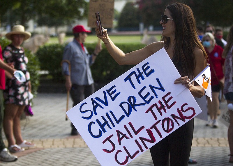 Staff photo by Troy Stolt / A protester holds a sign that reads "Save the children jail the Clintons" during the Save Our Children Rally in Coolidge Park on Saturday, Aug. 22, 2020 in Chattanooga, Tenn.