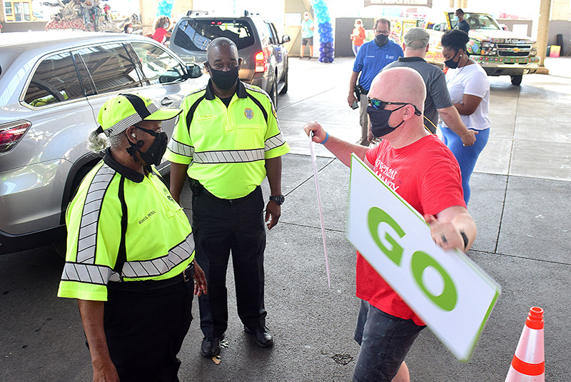 Staff Photo by Robin Rudd / School Patrol officers Everlina Spencer and Tony Hudson watch as Doug Smith demonstrates his "stop"/"go" sign technique.