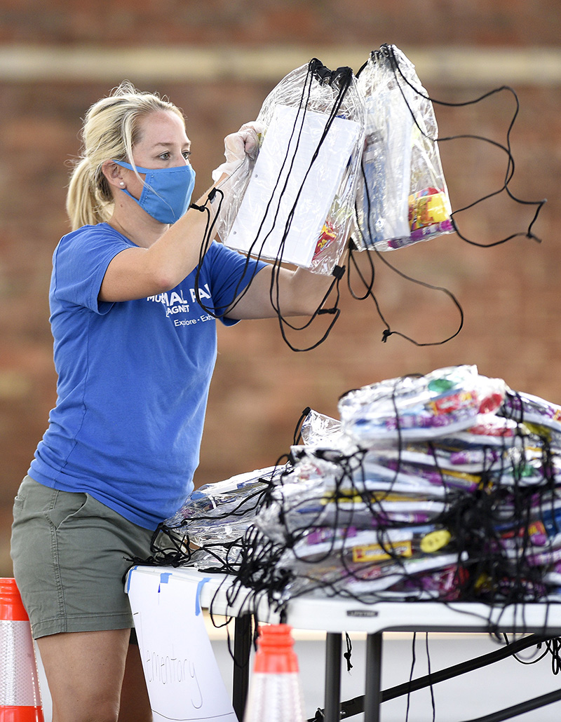 Staff Photo by Robin Rudd / Amanda Taylor arranges backpacks during a lull in the line.