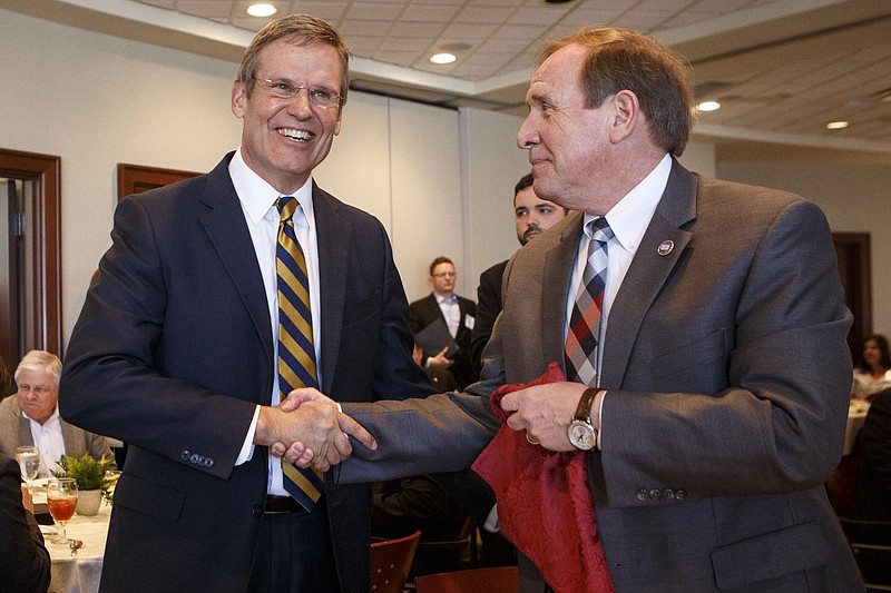 Staff photo by C.B. Schmelter / Gov. Bill Lee, left, shakes hands with state Rep. Mike Carter, R-Oolteway during a Chattanooga Area Chamber of Commerce luncheon in this March 22, 2019 file photo.