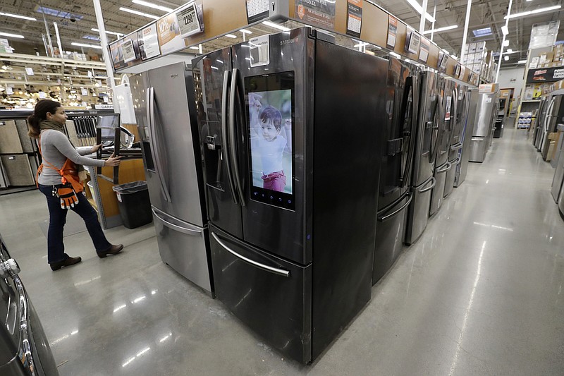 In this Jan. 27, 2020 file photo a worker pushes a cart past refrigerators at a Home Depot store location in Boston. On Thursday, June 25, orders to American factories for big-ticket goods rebounded last month from a disastrous May as the U.S. economy began to slowly reopen. (AP Photo/Steven Senne)