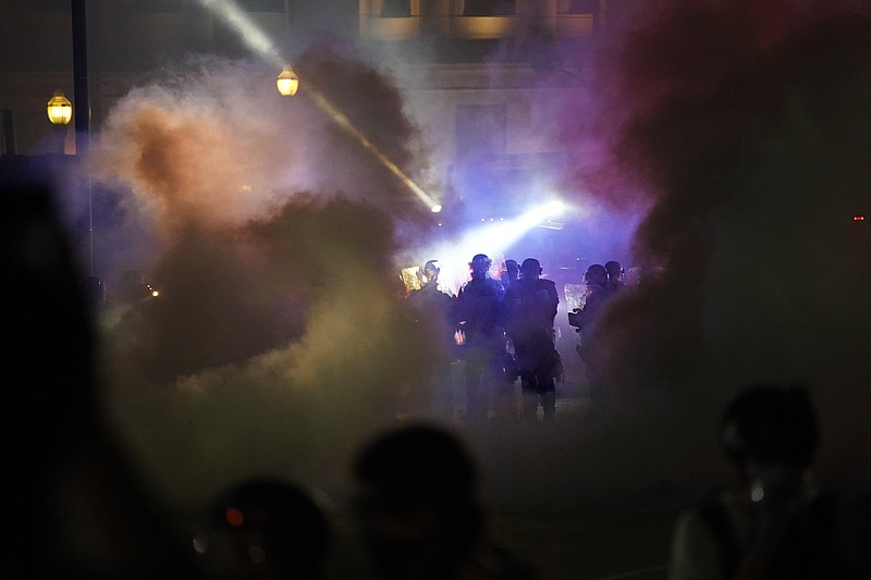 Police in riot gear clear the area in front of Kenosha County Courthouse during clashes with protesters late Tuesday, Aug. 25, 2020, in Kenosha, Wis. Protests continue following the police shooting of Jacob Blake two days earlier. (AP Photo/David Goldman)