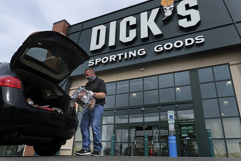 In this May 18, 2020 file photo, Gus Promollo delivers an order into a customer's trunk at Dick's Sporting Goods in Paramus, N.J. At home workouts and outdoor athletic activities are shaping up to be good business for Dick's Sporting Goods. The retailer's second-quarter results easily beat Wall Street's expectations, Wednesday, Aug. 26, as consumers continue to focus on health and wellness while stuck at home amid the coronavirus pandemic. (AP Photo/Seth Wenig, File)