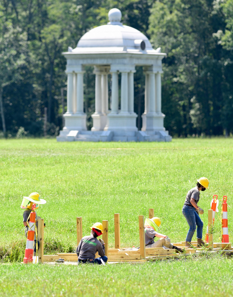 Staff Photo by Robin Rudd / The Florida Monument stands in the background as a Southeast Conservation Corps team builds a bridge across a stream in McDonald Field inside Chickamauga and Chattanooga National Military Park. SECC operates conservation service programs throughout the Southeast that focus on environmental stewardship.