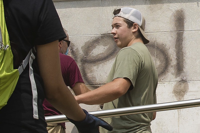 Kyle Rittenhouse, who is charged with first-degree intentional homicide for shooting protesters in Kenosha Tuesday night, helps clean the exterior of Reuther Central High School Tuesday morning, Aug. 25, 2020. Two protesters were fatally shot and one injured. | Pat Nabong/Sun-Times