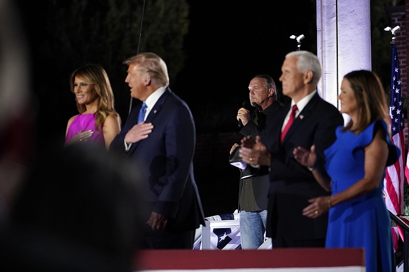 President Donald Trump and first lady Melania Trump stand with Vice President Mike Pence and Karen Pence as Trace Adkins sings the National Anthem on the third day of the Republican National Convention at Fort McHenry National Monument and Historic Shrine in Baltimore, Wednesday, Aug. 26, 2020. (AP Photo/Andrew Harnik)