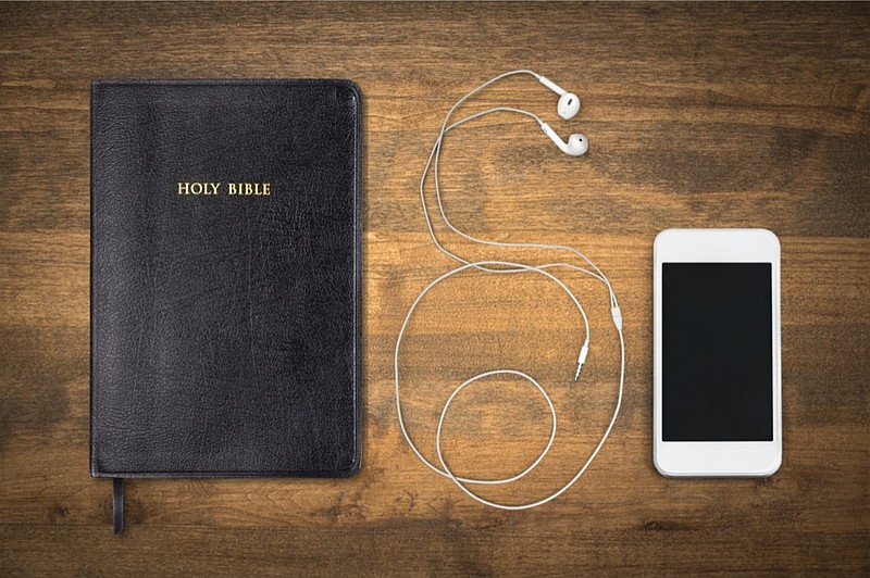 Holy Bible book and smartphone with earphones on background bible tile faith prayer church tile / Getty Images
