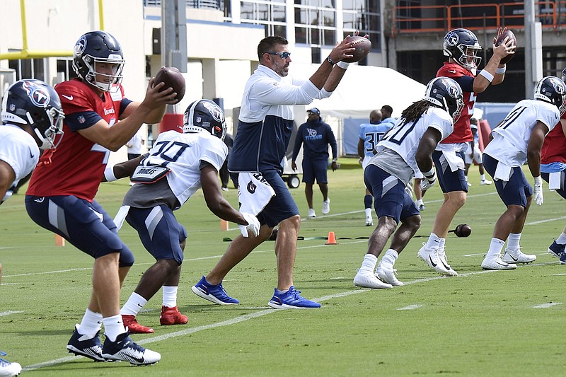 AP photo by George Walker IV / Tennessee Titans coach Mike Vrabel, center, fills in at a quarterback spot for a drill during training camp Thursday in Nashville.