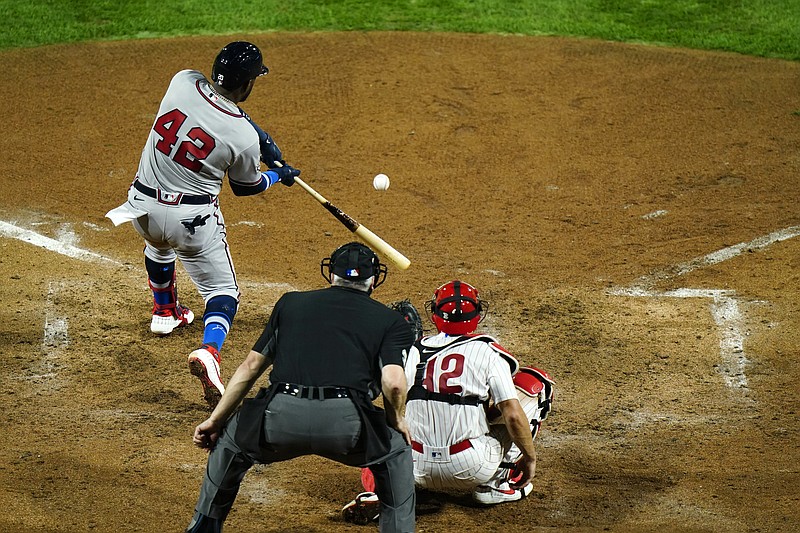 AP photo by Matt Slocum / The Atlanta Braves' Marcell Ozuna, left, drives in a run off Philadelphia Phillies pitcher Zack Wheeler during the sixth inning of Friday night's game in Philadelphia. Ozuna was safe at first on a throwing error by shortstop Didi Gregorius.