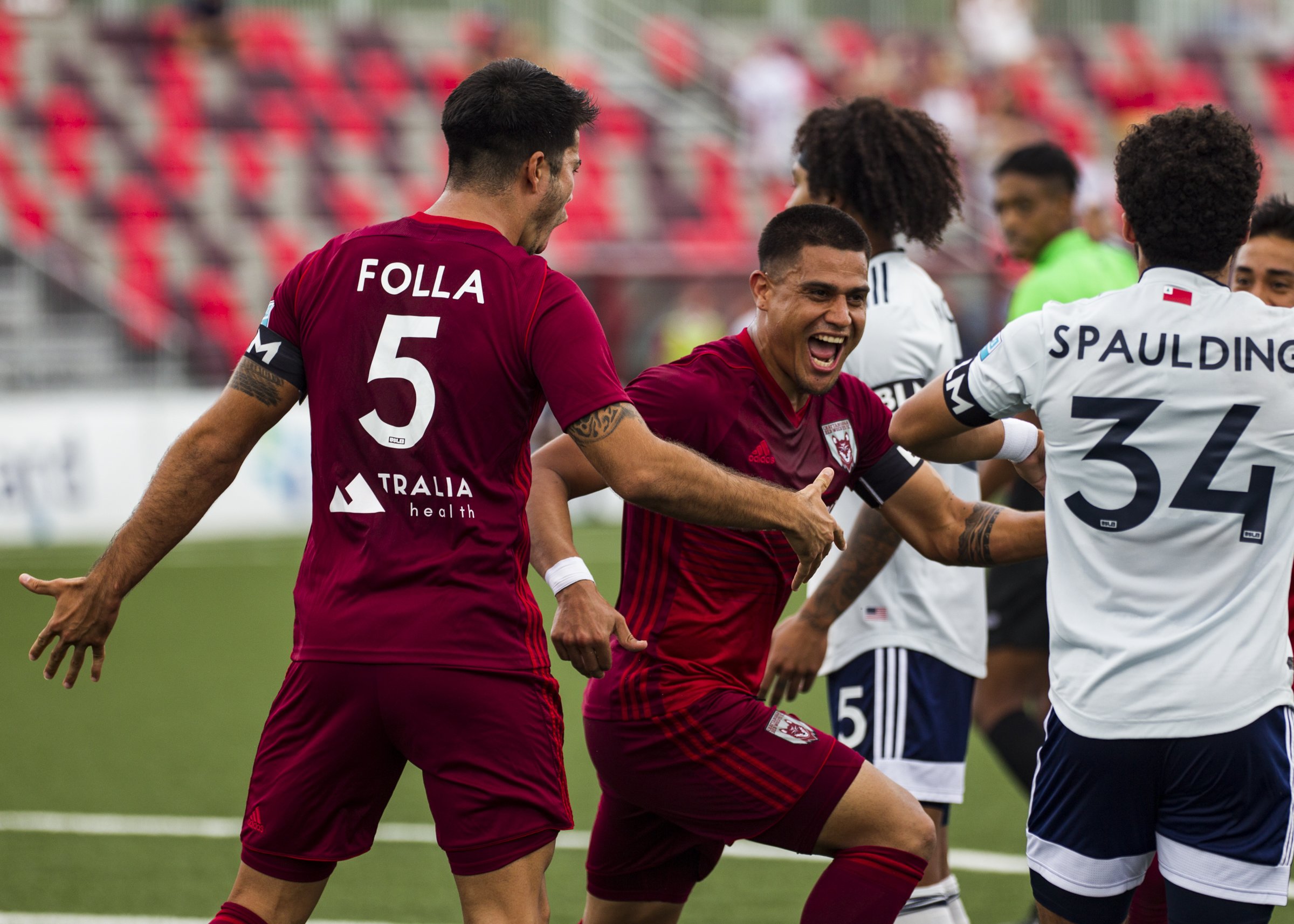 Staff photo by Troy Stolt / Chattanooga forward Ricardo Zacarias, center, celebrates after scoring a goal during the Red Wolves' 4-0 victory against the New England Revolution II on Saturday at CHI Memorial Stadium in East Ridge.
