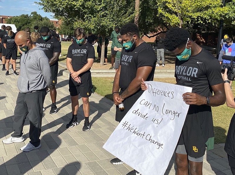 AP photo by Rod Aydelotte / Members of the Baylor University football program, including coach Dave Aranda, left, bow their heads during a prayer after marching around campus Thursday in Waco, Texas, to protest the shooting of Jacob Blake, a Black man, by police in Kenosha, Wisconsin.