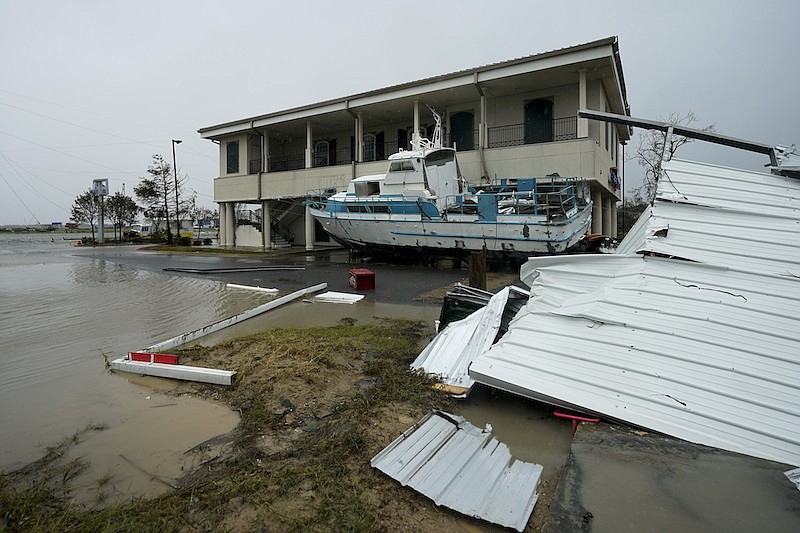 Flooding surrounds a damaged building and boat Friday, Aug. 28, 2020, in Cameron, La., after Hurricane Laura moved through the area Thursday. (AP Photo/David J. Phillip)