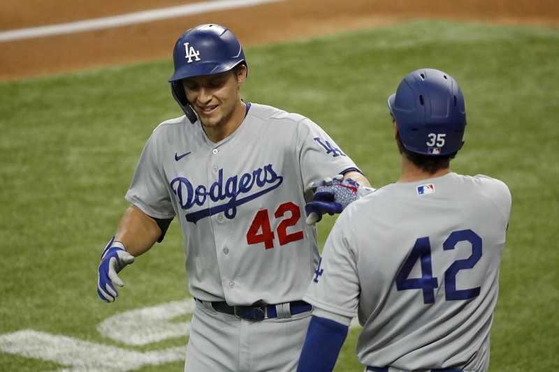 Los Angeles Dodgers' Corey Seager, left, is congratulated by Cody Bellinger, right, after a solo home run during the first inning of a baseball game against the Texas Rangers in Arlington, Texas, Sunday, Aug. 30, 2020. (AP Photo/Roger Steinman)