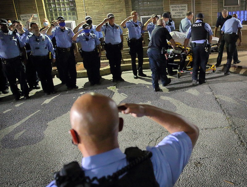 St. Louis police officers line up and salute as the body of fallen Officer Tamarris L. Bohannon is brought to the morgue in St. Louis, Sunday, Aug. 30, 2020. Bohannon died Sunday after being shot in the head by a barricaded gunman on the city's south side, authorities said. (David Carson/St. Louis Post-Dispatch via AP)