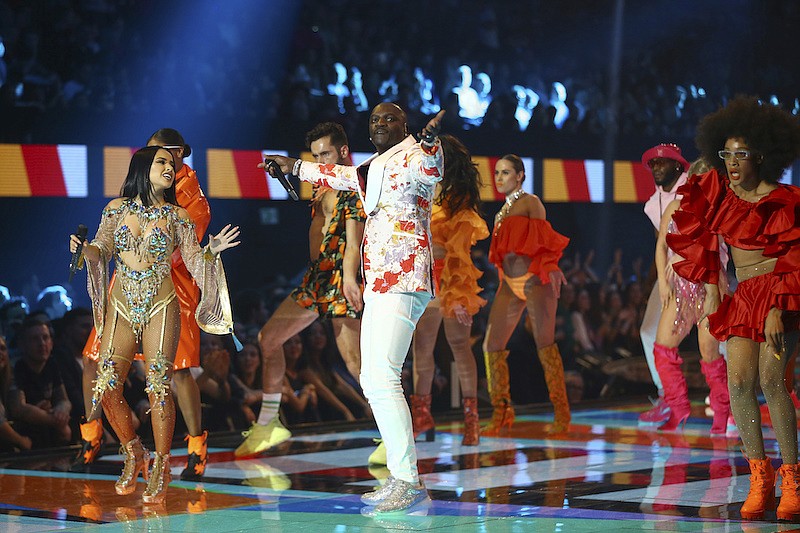 In this Sunday, Nov. 3, 2019, file photo, singers Becky G, left, and Akon, center, perform during the European MTV Awards in Seville, Spain. American R&B singer Akon is moving ahead with plans to create a futuristic pan-African city, announcing Monday, Aug. 31, 2020 that construction will begin next year on the $6 billion project despite global tourism's uncertain future. (Photo by Joel C Ryan/Invision/AP, File)