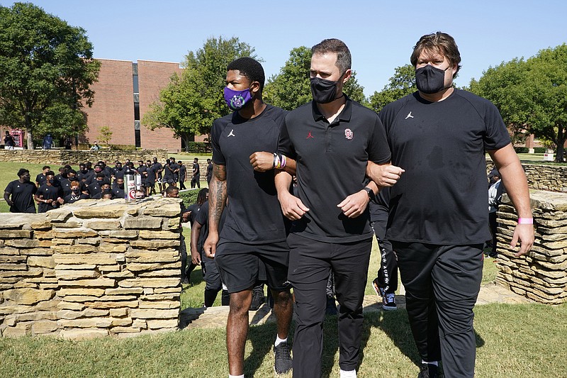 AP photo by Sue Ogrocki / University of Oklahoma football coach Lincoln Riley, center, is flanked by safety Chanse Sylvie, left, and Creed Humphrey, right, as they lead the team from the Unity Garden after they held a 57-second moment of silence in honor of the 57-year anniversary of the March on Washington and Martin Luther King Jr.'s "I Have a Dream" speech on Aug. 28.