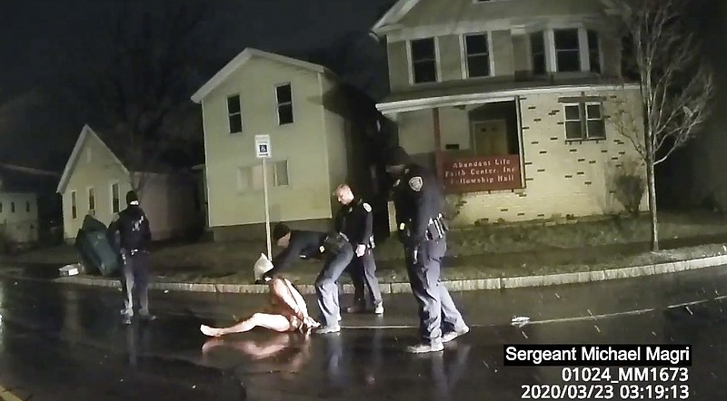 In this image taken from police body camera video provided by Roth and Roth LLP, a Rochester police officer puts a hood over the head of Daniel Prude, on March 23, 2020, in Rochester, N.Y. Video of Prude, a Black man who had run naked through the streets of the western New York city, died of asphyxiation after a group of police officers put a hood over his head, then pressed his face into the pavement for two minutes, according to video and records released Wednesday, Sept. 2, 2020, by the man's family. Prude died March 30 after he was taken off life support, seven days after the encounter with police in Rochester. (Rochester Police via Roth and Roth LLP via AP)