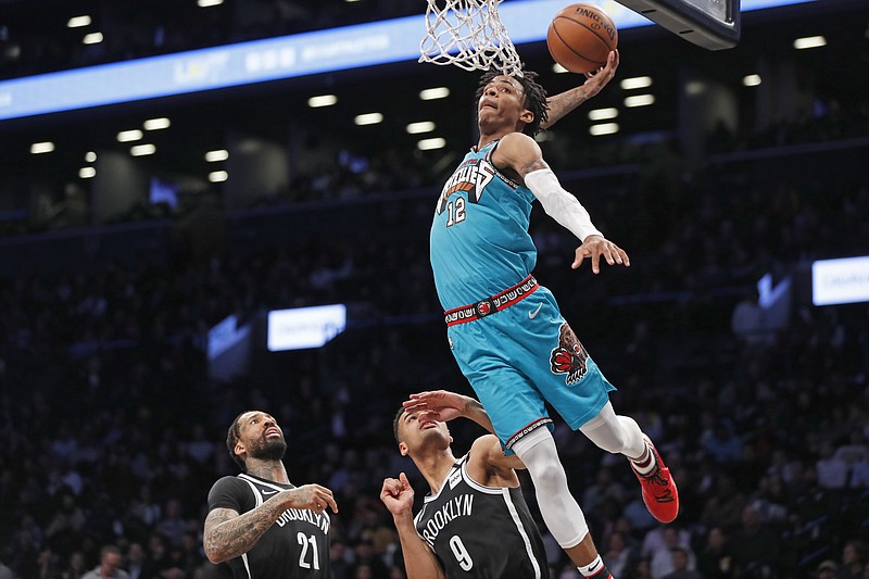 AP photo by Kathy Willens / Memphis Grizzlies guard Ja Morant goes up for a dunk as Brooklyn Nets forward Wilson Chandler, left, and guard Timothe Luwawu-Cabarrot watch during the second half of their teams' March 4 matchup in New York.