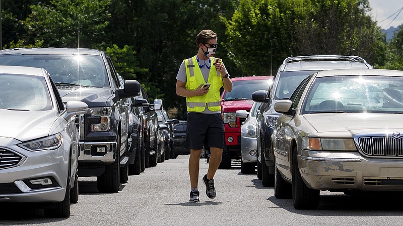 Staff photo by C.B. Schmelter / Physical education teacher Taylor Lamunyon helps organize the dismissal of car riders at Battle Academy on Monday, Aug. 31, 2020 in Chattanooga, Tenn.