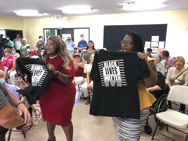 Triana Arnold James, left, and Nselaa Ward hold up Black Lives Matter T-shirts as they protest a speech by U.S. Sen. Kelly Loeffler, Thursday, Sept 3, 2020, in Cumming, Ga. James and Ward kept Loeffler from finishing a campaign speech. (AP Photo/Jeff Amy)