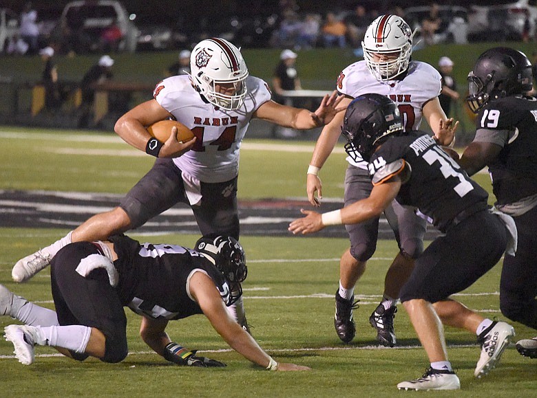 Staff photo by Matt Hamilton / Rabun County's Gunner Stockton jumps over one defender and stiff-arms another on a rush during Friday's shutout win at Ridgeland.