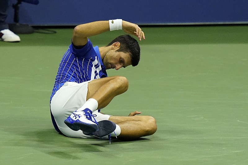 AP photo by Frank Franklin III / Novak Djokovic falls during his third-round match against Jan-Lennard Struff at the U.S. Open on Friday night in New York. Djokovic cruised to a straight-sets sweep to reach the fourth round and improve to 26-0 this season.
