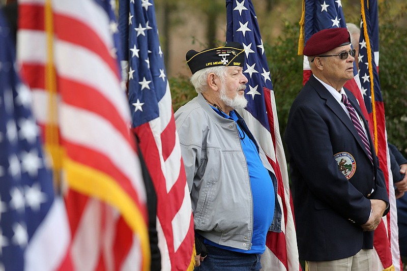 Staff photo by Erin O. Smith / David Wooden, a U.S. Marine Corps veteran, and Roger Taylor, a U.S. Army veteran, stand with flags following Massing the Colors during the Veterans Day Program at the Chattanooga National Cemetery Monday, November 11, 2019 in Chattanooga, Tennessee. 
