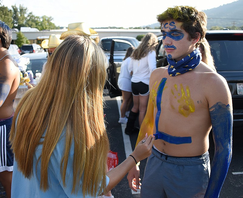 Staff photo by Matt Hamilton / Riley Anand, left, paints the chest of Cameron Heilig before the start of Chattanooga Christian's home football game against Baylor on Friday night.