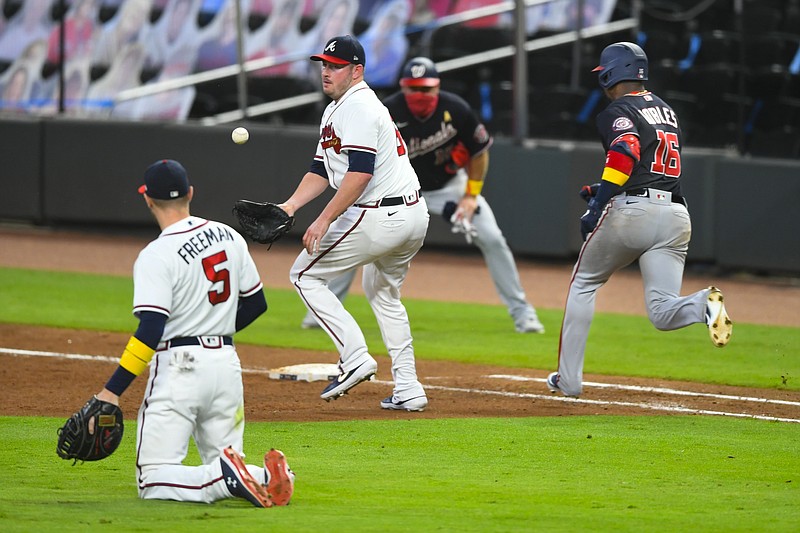 AP photo by John Amis / Atlanta Braves relief pitcher Tyler Matzek, center, cannot get a glove on a toss from first baseman Freddie Freeman as the Washington Nationals' Victor Robles runs safely to first on an RBI bunt during the sixth inning of Saturday night's game in Atlanta.