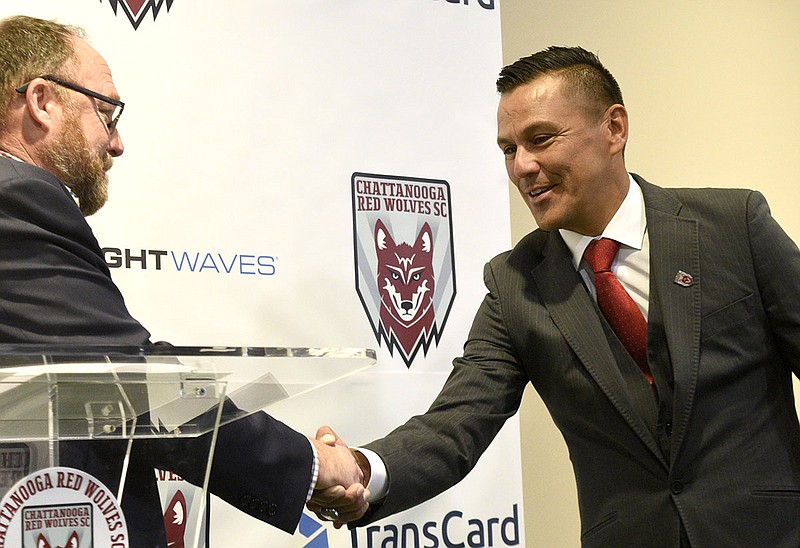 Staff photo by Robin Rudd / Chattanooga Red Wolves SC team president and general manager Sean McDaniel, left, shakes Jimmy Obleda's hand during a news conference introducing him as the team's new coach on Nov. 21, 2019.