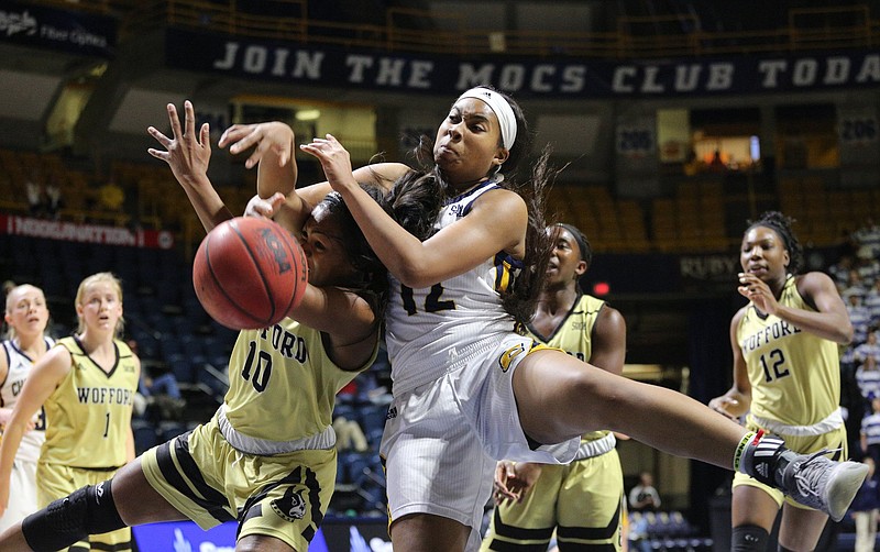 Staff photo / UTC's Bria Dial, right, and Wofford's Cairo Booker collide as they compete for a rebound during a SoCon game on Dec. 17, 2019, at McKenzie Arena.