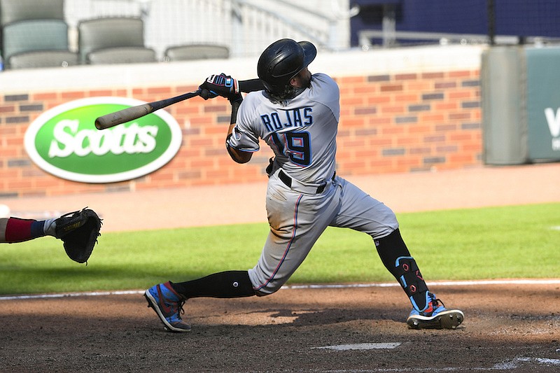 AP photo by John Amis / Miami's Migual Rojas follows through on a go-ahead one-run double to center field during the 10th inning of the Marlins' game against the host Atlanta Braves on Monday.