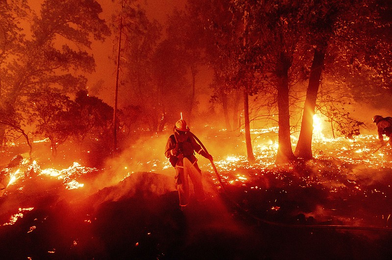  In this Sept. 7, 2020, file photo, a firefighter battles the Creek Fire as it threatens homes in the Cascadel Woods neighborhood of Madera County, Calif. Climate-connected disasters seem everywhere in the crazy year 2020. But scientists Wednesday, Sept. 9, say it'll get worse. (AP Photo/Noah Berger, File)