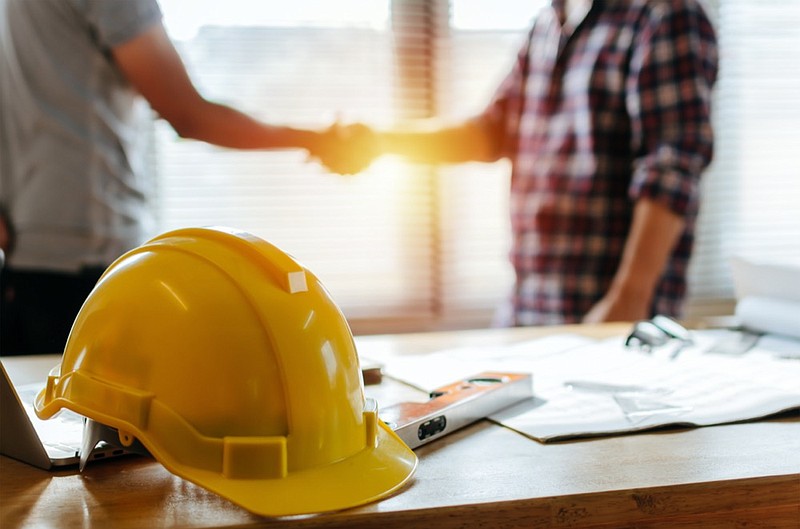 top view hand shake of engineer and building contractor on table - stock photo contractor tile construction tile / Getty Images
