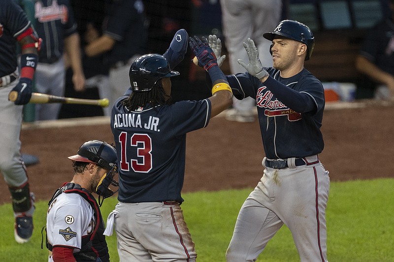 AP photo by Manuel Ceneta / Atlanta Braves first baseman Freddie Freeman, right, is congratulated at home plate by teammate Ronald Acuna Jr. next to Washington Nationals catcher Yan Gomes after hitting a two-run home run during the fourth inning of Thursday night's game in Washington.