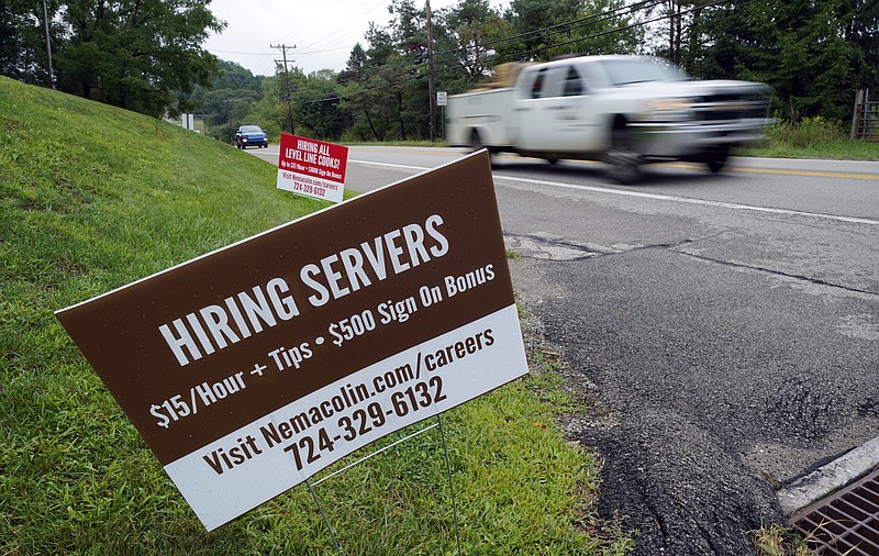  In this Wednesday, Sept. 2, 2020, file photo help wanted signs for servers and cooks at Nemacolin Woodlands Resort and Spa are displayed along route 40 at the entrance to the resort in Farmington, Pa. U.S. employers advertised more jobs but hired fewer workers in July, sending mixed signals about a job market in the wake of the coronavirus outbreak. The Labor Department said Wednesday, Sept. 9, 2020, that the number of U.S. job postings on the last day of July rose to 6.6 million from 6 million at the end of June. (AP Photo/Gene J. Puskar, File)