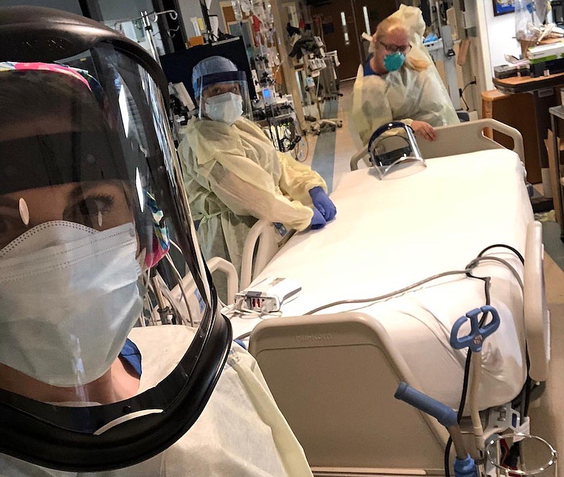 Andrea Gilliam, front, an Erlanger clinical staff leader and critical care nurse, wears personal protective equipment needed to safely care for COVID-19 patients. Fellow critical care nurses Charley Jeffries and Megan Farquhar stand behind Gilliam. / Contributed photo 

