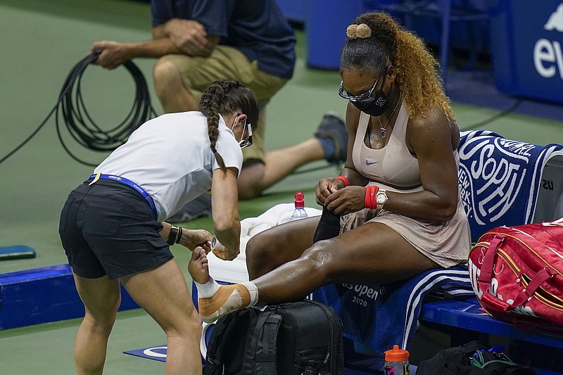 AP photo by Seth Wenig / Serena Williams has her ankle taped by a trainer during a U.S. Open semifinal against Victoria Azarenka on Thursday night in New York.